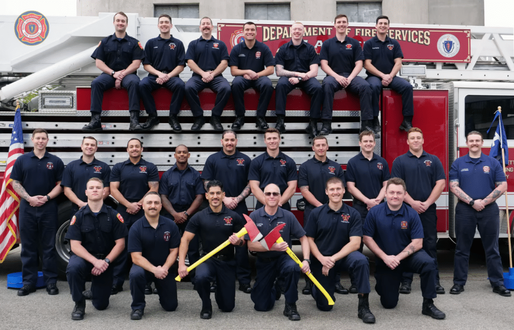 Firefighters sit in front of and on truck